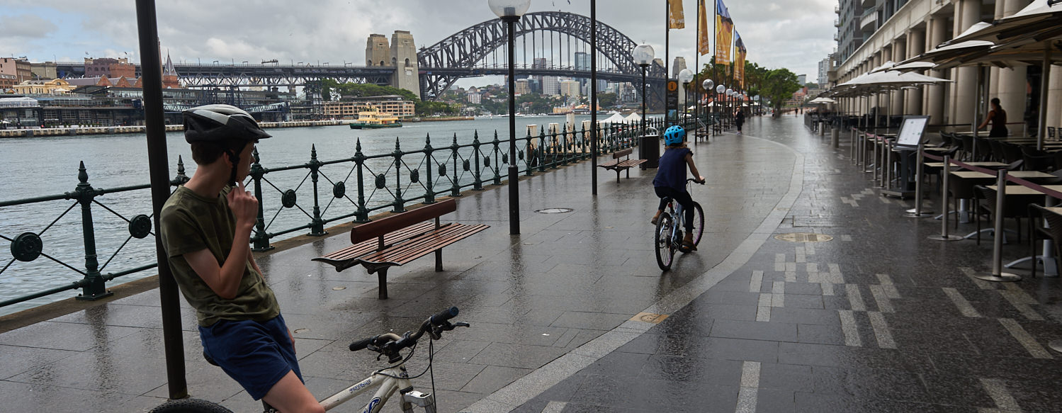 Cycling at circular quay with the Sydney Harbour Bridge behind.